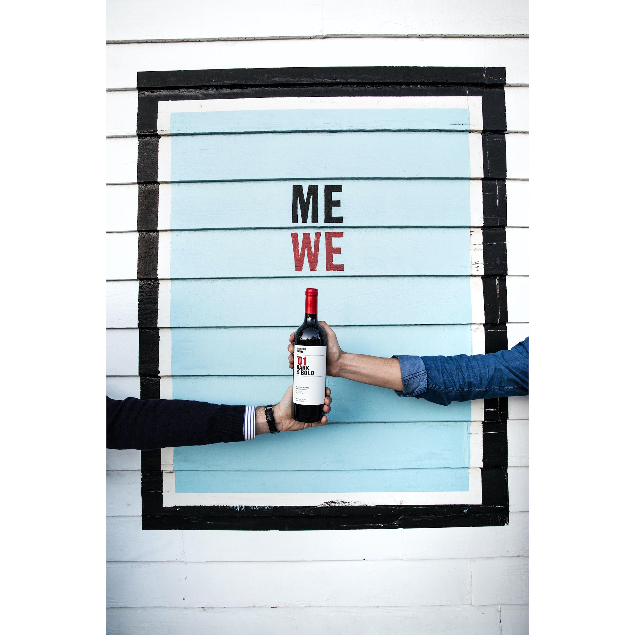 Bottle of Obvious Wines' Dark & Bold red blend being held by two hands