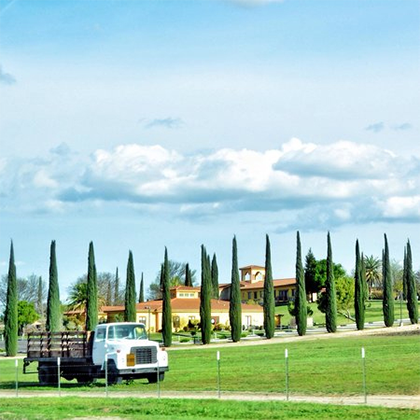 Daytime photo of Broken Earth Winery featuring large house and truck