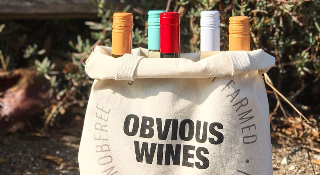 a bunch of Obvious Wines bottles in a cloth sack