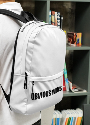 Person wearing white backpack with Obvious Wines text on the front